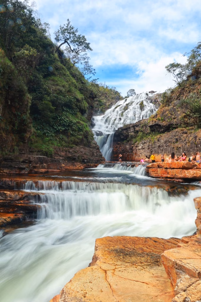 Cachoeira Almécegas Mil no complexo da Catarata dos Couros, mostrando o fluxo da água descendo por degraus de pedras  com turistas nas encostas, Chapada dos Veadeiros.